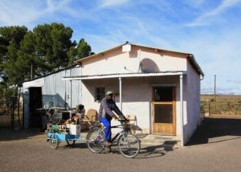 Max Ndamane, with the bicycle-drawn trailer he made for his gardening services in Richmond, in front of the old ramstal he turned into a home. Photo: Chris Marais