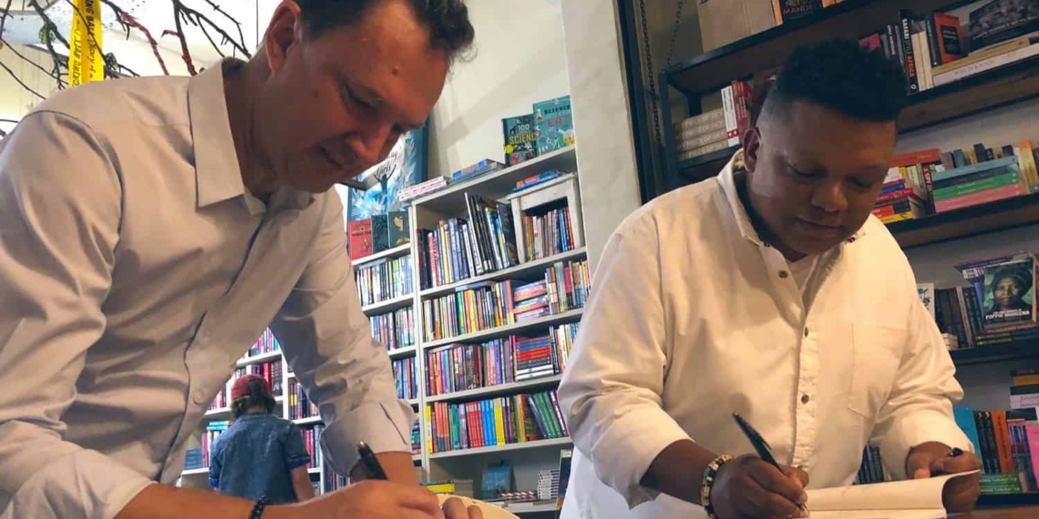 "For the Love of the Land" authors Kobus Louwrens and Ivor Price signing copies of their new book during the launch function at Love Books in Melville, Johannesburg.