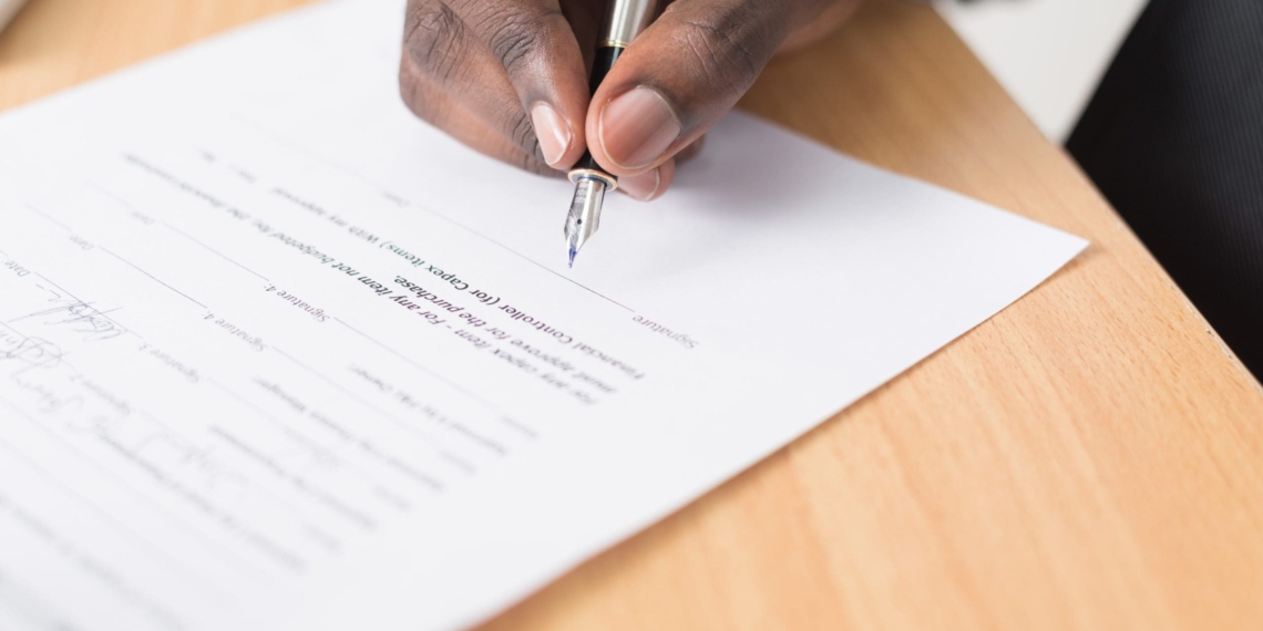 Man signing a contract. Unsplash picture