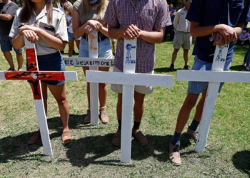 Farmers hold white crosses during an earlier protest against farm murders and attacks. Residents are anxiously awaiting the implementation of the rural safety strategy. Photo: Phill Magakoe/AFP via Getty Images