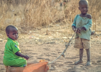 Hold on baby! Amina carries her baby in traditional style as she does household chores in the Nigerian communal centre at Malkoli in 2016.