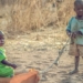 Hold on baby! Amina carries her baby in traditional style as she does household chores in the Nigerian communal centre at Malkoli in 2016.