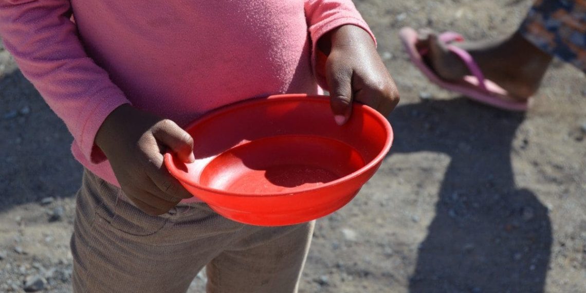 A South African child waits for a bowl of food during hard lockdown in April 2020. Photo: Elana van der Watt/Food For Mzansi