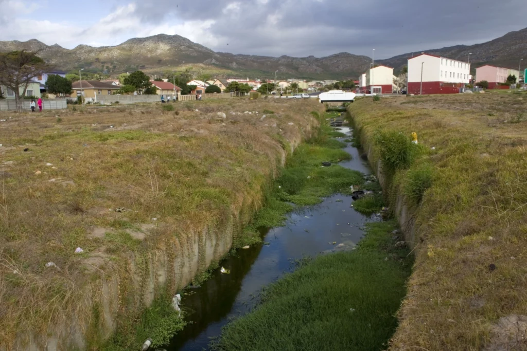 A polluted stream runs through the urban area of Ocean View in Cape Town on 8 March 2011. Lack of infrastructure in the rapidly expanding lower-income urban areas across South Africa has caused severe water management issues for local governments. The flow of urban streams and stormwater drains is blocked in many areas with high levels of pollution due to the lack of waste removal services. Photo: Supplied/EPA/Nic Bothma