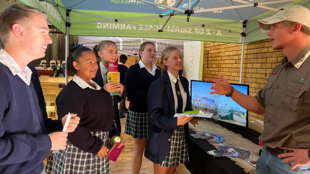 Learners engage with Agri Skills Transfer representatives to learn about their accredited training programs aligned with the National Qualification Framework, aimed at equipping them with in-demand skills and competencies for success in the agricultural sector. Photo: Ivor Price/Food For Mzansi