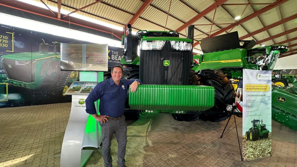 Agriculture minister John Steenhuisen embraces agricultural innovation at Nampo Harvest Day in Bothaville, Free State, posing with a John Deere tractor. Photo: Supplied/Food For Mzansi