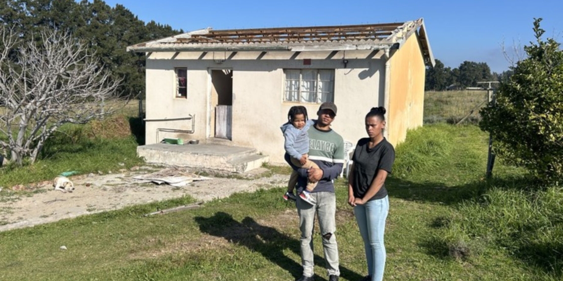 Haven Smith with his three-year-old son, Shaquille, and partner, Shannon van der Vyfer, is one of three families facing eviction from Barton Vineyards and Villas near Botrivier in the Western Cape. Earlier this month, the farm owner removed the roof of their home. Photo: Rasaad Adams/GroundUp
