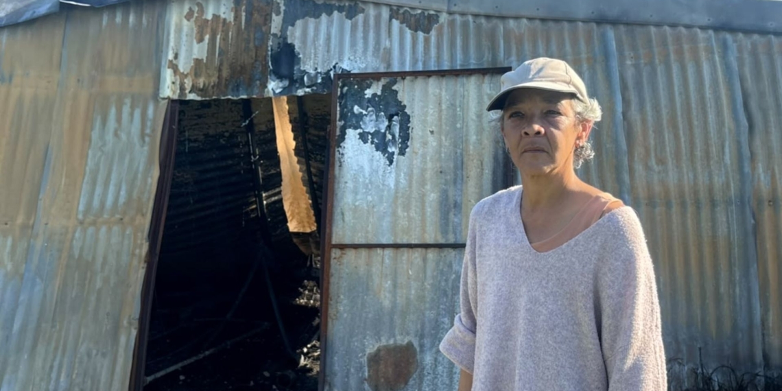 Rafaella Pietersen standing outside the remains of her self-built poultry structure in Dal Josafat, Paarl, after it was destroyed by a fire following a stock theft raid. Photo: Meshaan Van Wyk/Food For Mzansi